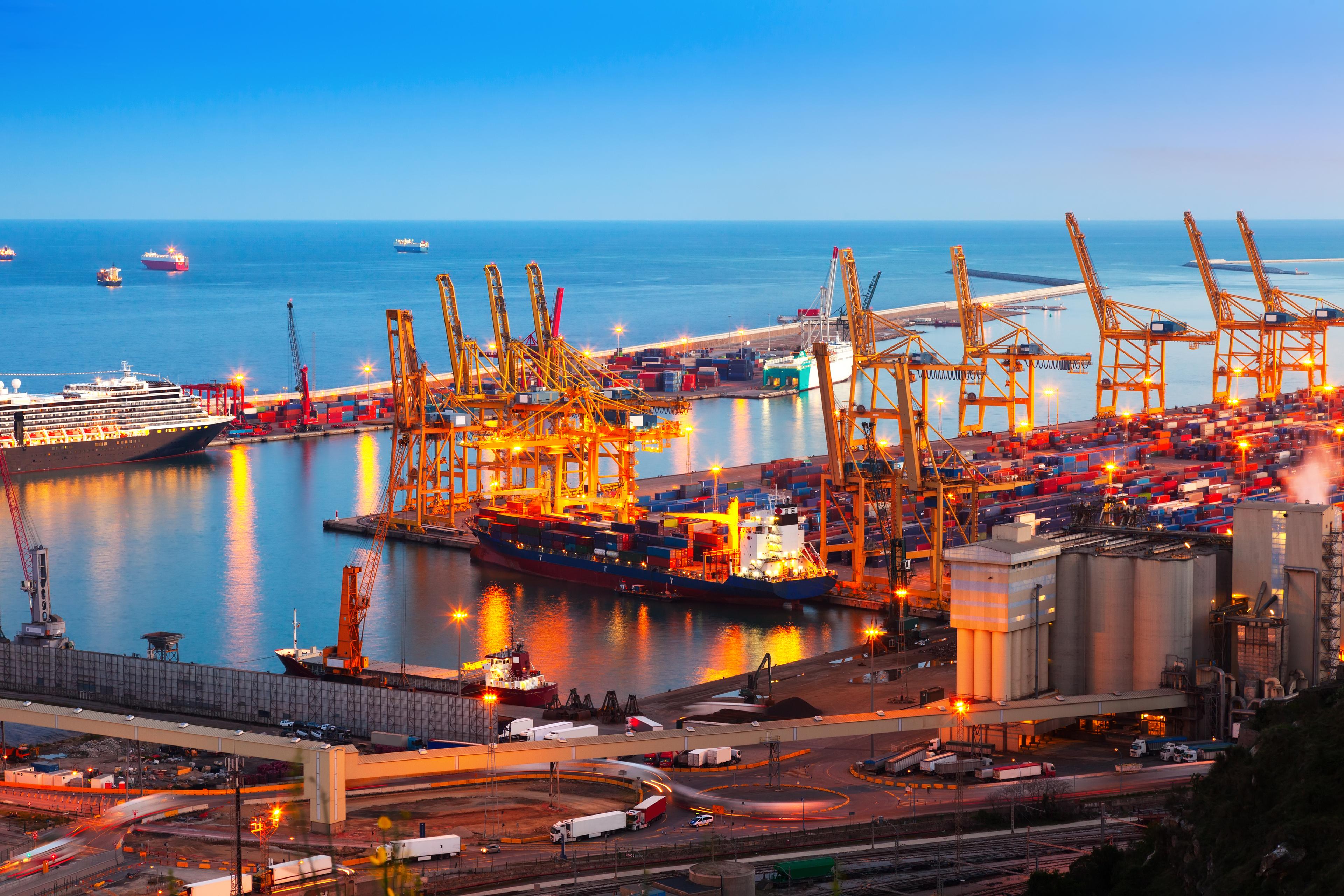 Illustrative cargo port at dusk with ships and container cranes