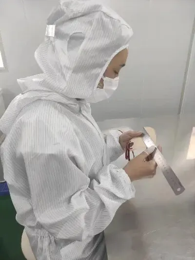 Quality-control worker manually checking a mask and its straps
