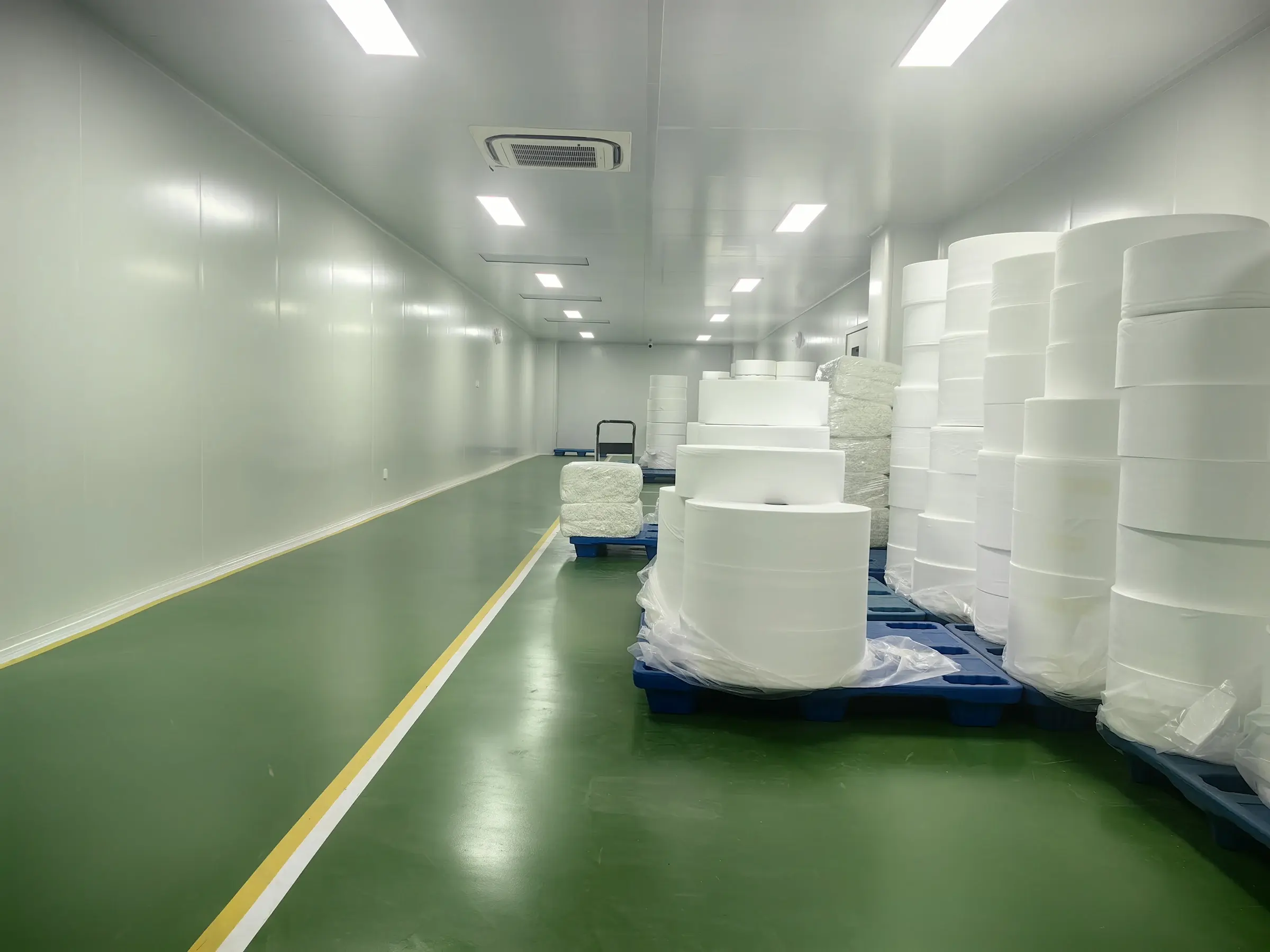 Nonwoven roll materials staged in the controlled material buffer room