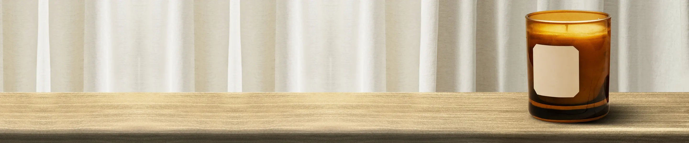 Amber scented candle jar on a wooden table